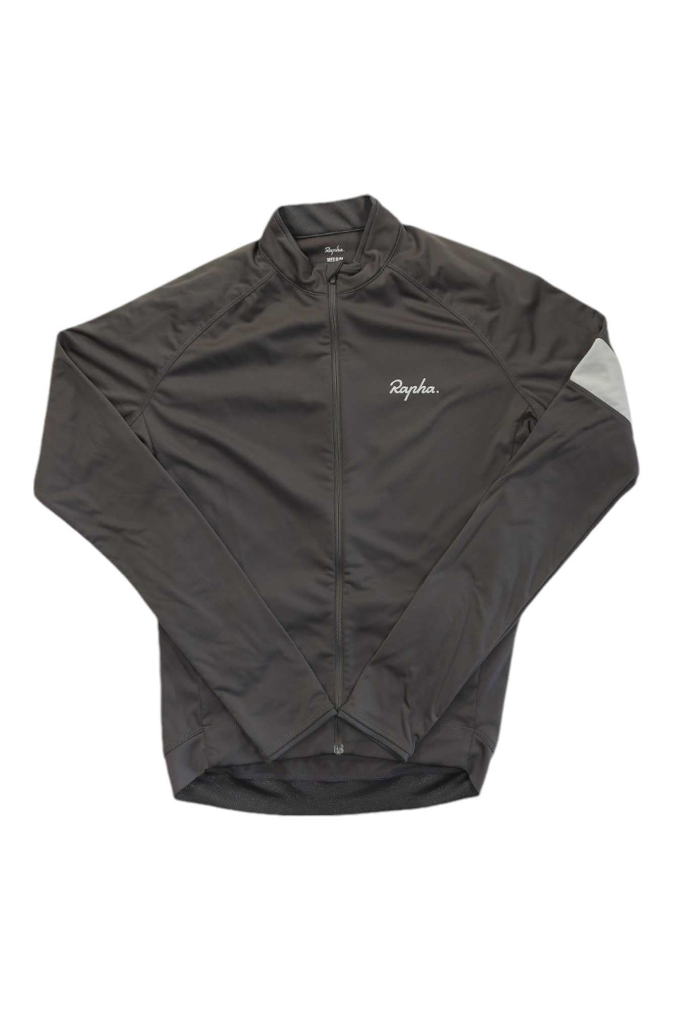 The Rapha Mens Core Long Sleeve Jersey, shown flat on a white background, is dark gray with long sleeves, a front zipper, left-chest Rapha logo, and features moisture-wicking fabric.