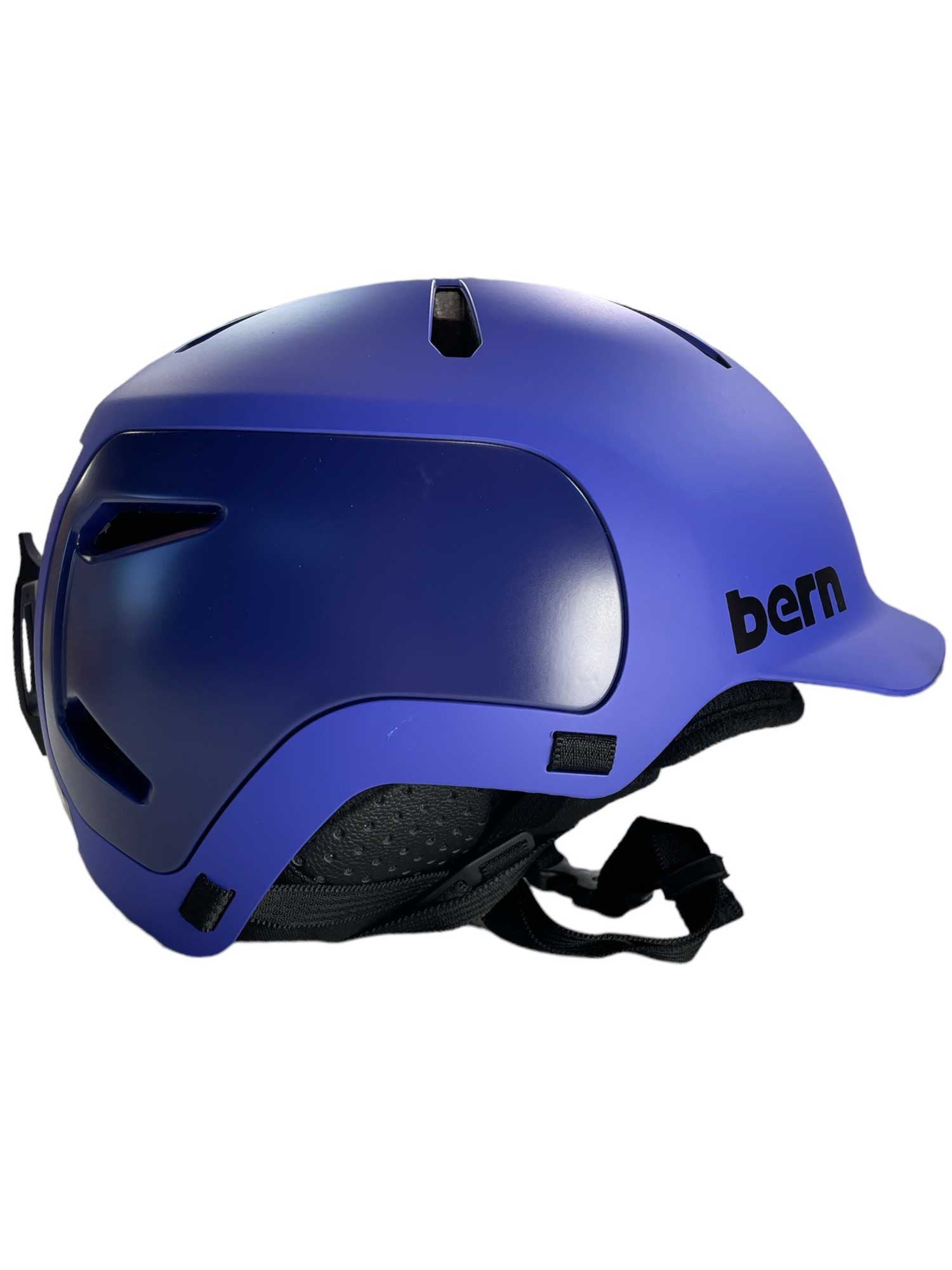 A side view of the Bern Watts 2.0 Helmet in blue matte, featuring ventilation slots, MIPS for impact protection, a short brim, black straps, and the bern logo on the side.