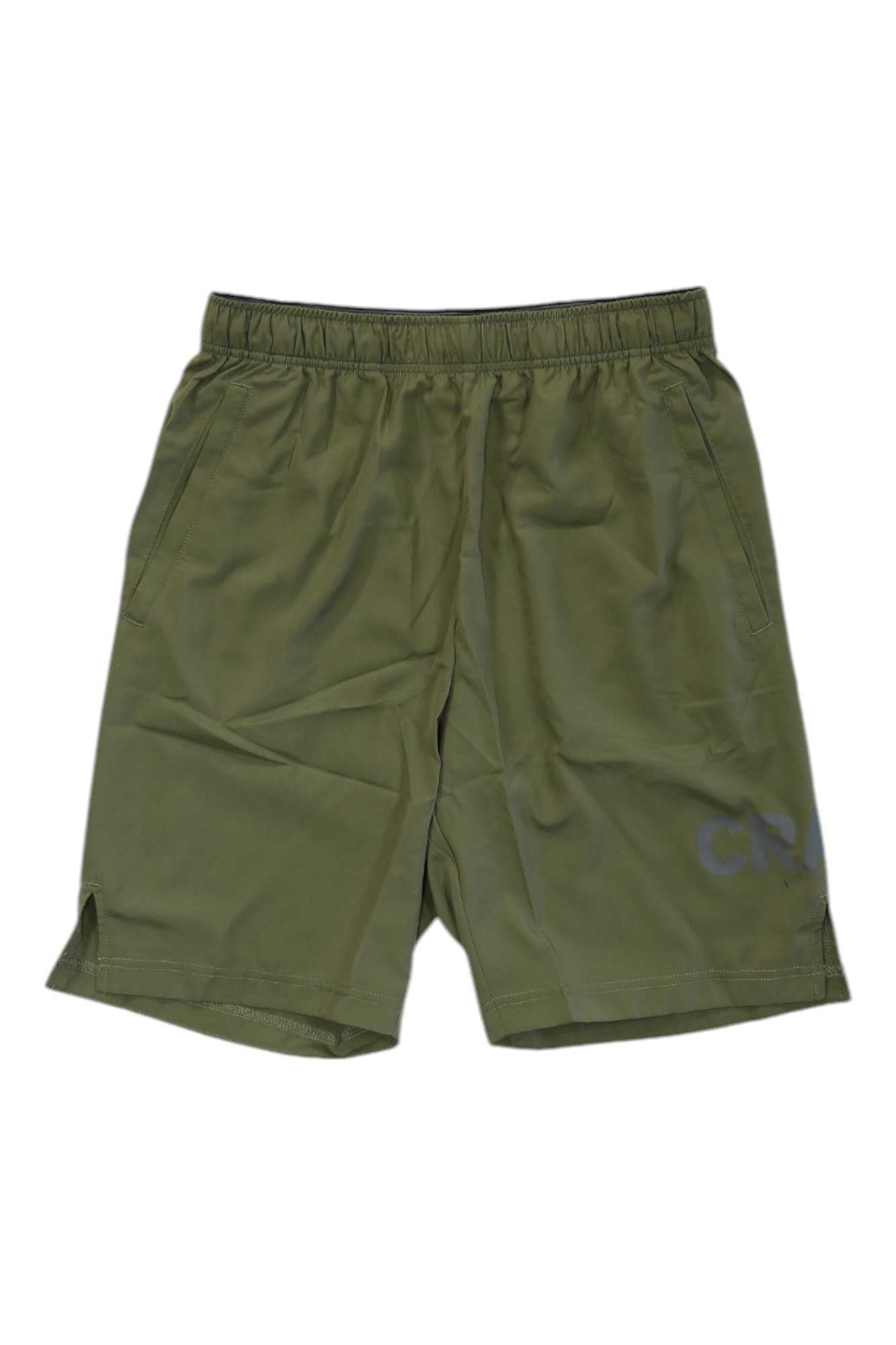 The Craft Sportswear Mens Core Charge Short in olive green features an adjustable waist, two side pockets, small CR logo on the lower right leg, side slits, a moisture-wicking fabric, and a slightly wrinkled look.