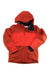 The Spyder Women's Field Jacket is a red insulated ski jacket with a hood, front zipper, black lining, long sleeves, and Spyder branding on the bottom hem. This waterproof jacket is displayed flat on a white background.