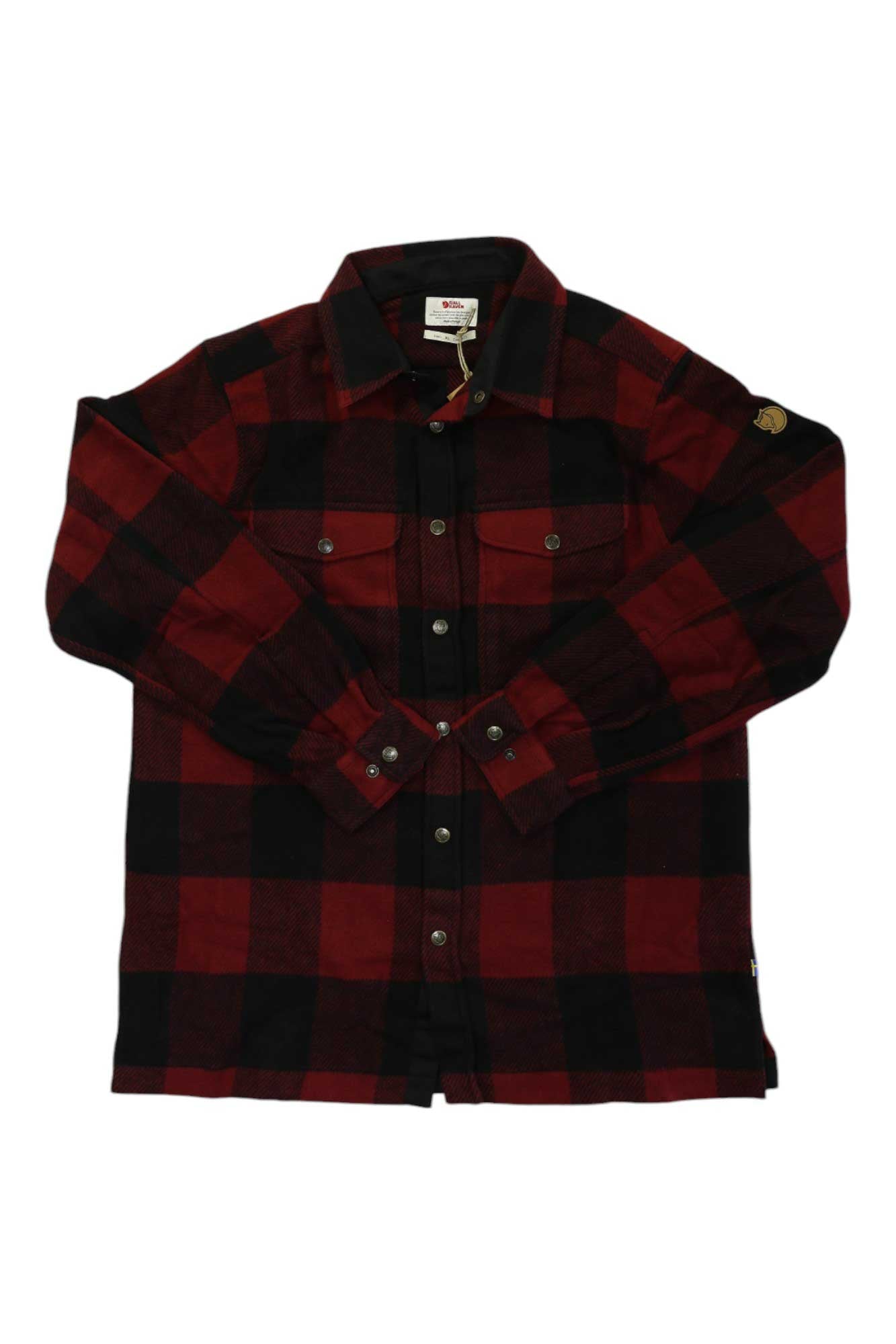 The Canada Shirt is a long-sleeve, button-up wool shirt in red and black plaid, with two chest pockets—ideal for casual travel.