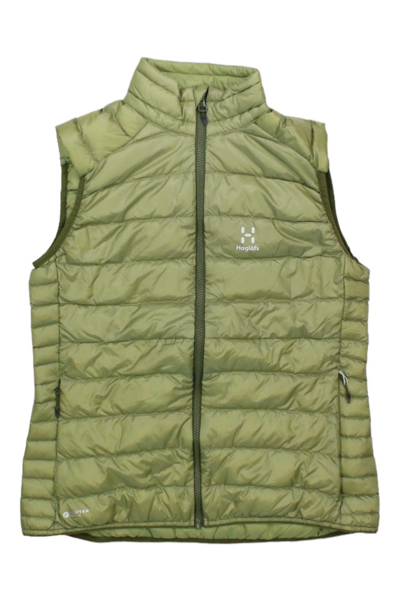 The Haglofs Womens Roc Down Vest is a light olive-green, sleeveless vest featuring a front zipper, side pockets, high collar, lightweight insulation, and the Haglöfs logo on the chest.