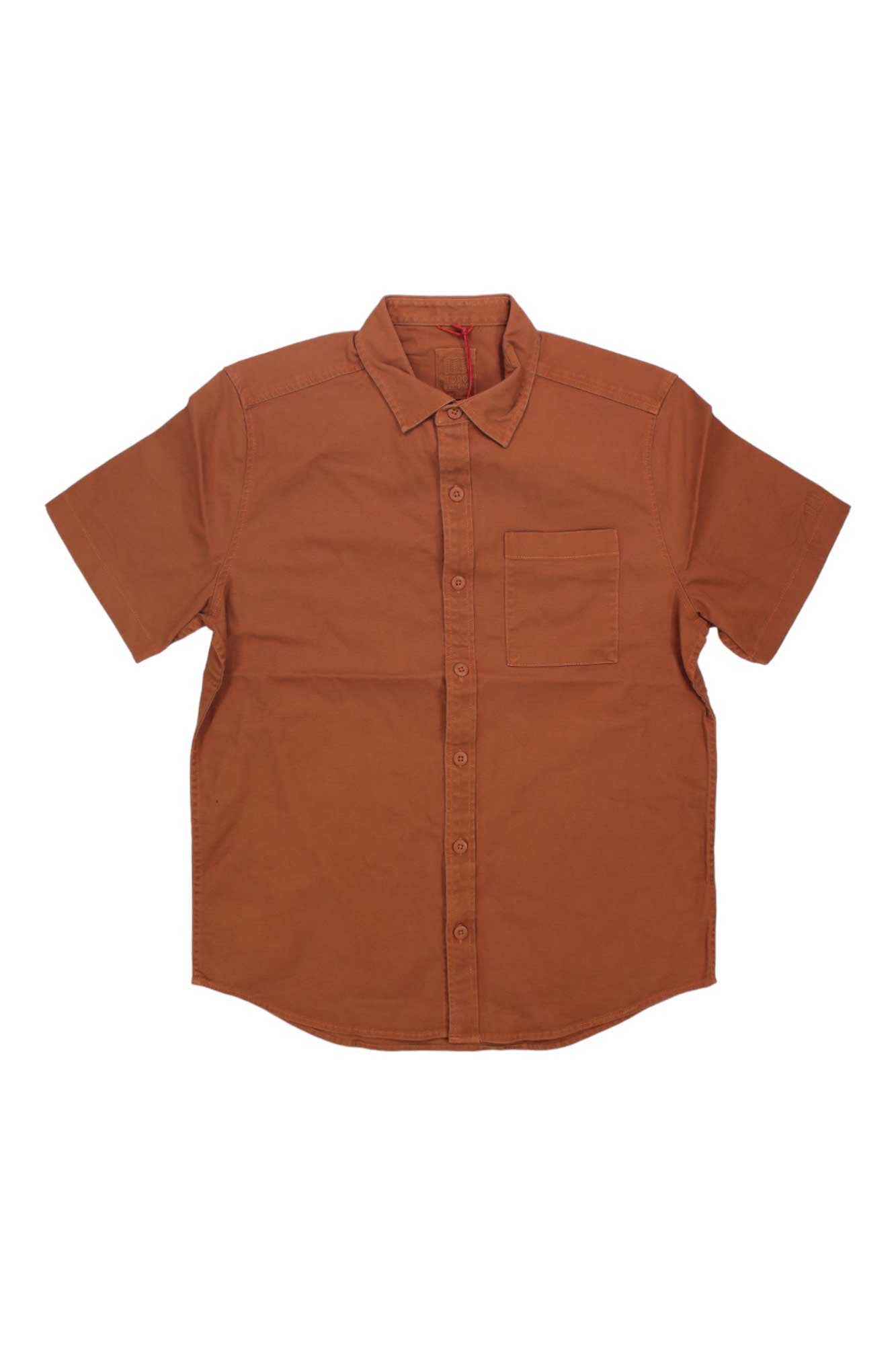 The Topo Designs Mens Dirt SS Shirt is a short-sleeved, button-up organic cotton shirt in solid rust brown with a front chest pocket, shown flat on a white background.