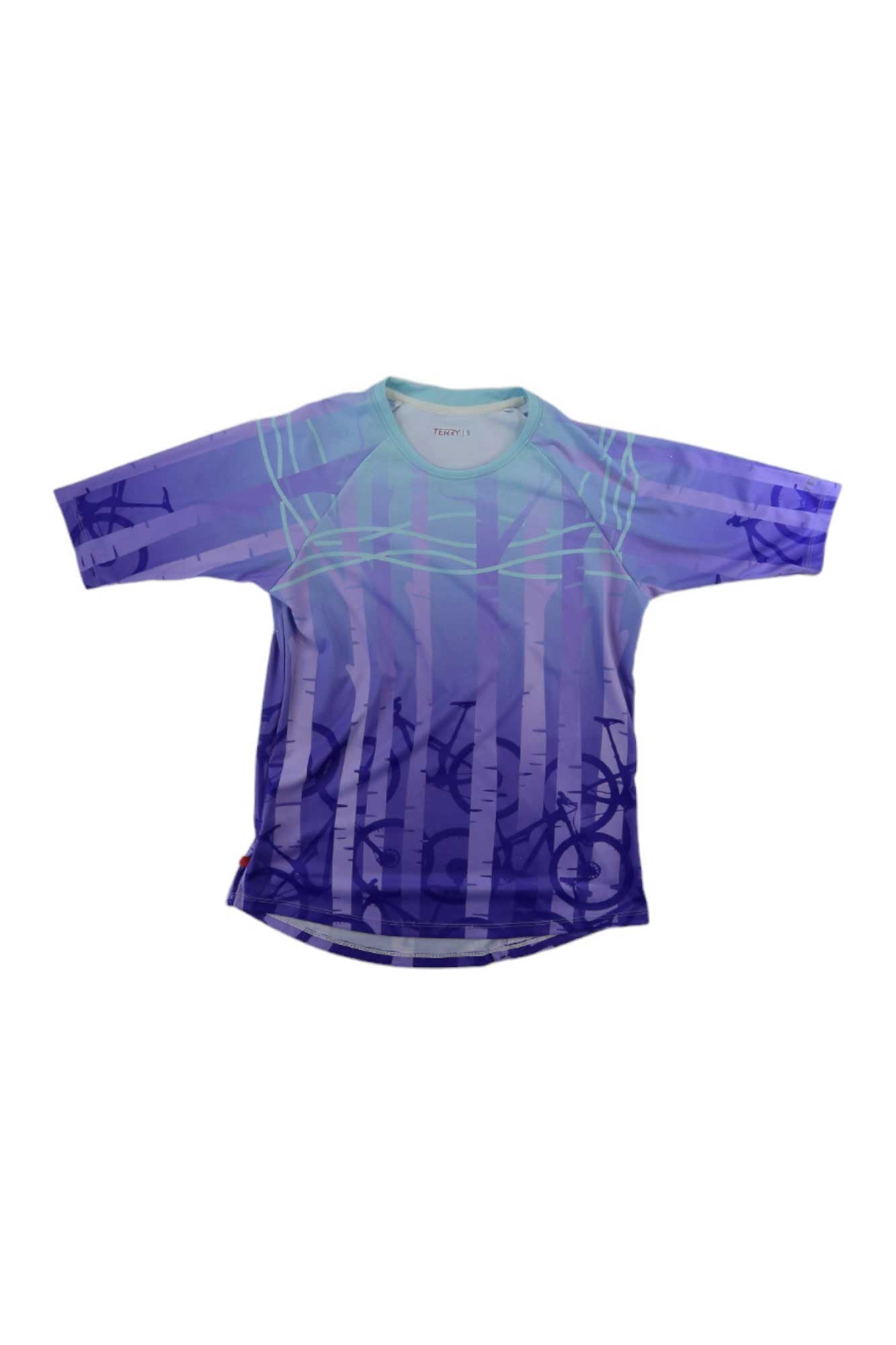 The Terry Womens Vista Top is a loose-fit, short-sleeved shirt with a purple and blue geometric pattern, subtle abstract designs, UV-resistant fabric, and is inspired by modern cycling tops. Displayed flat on a white background.