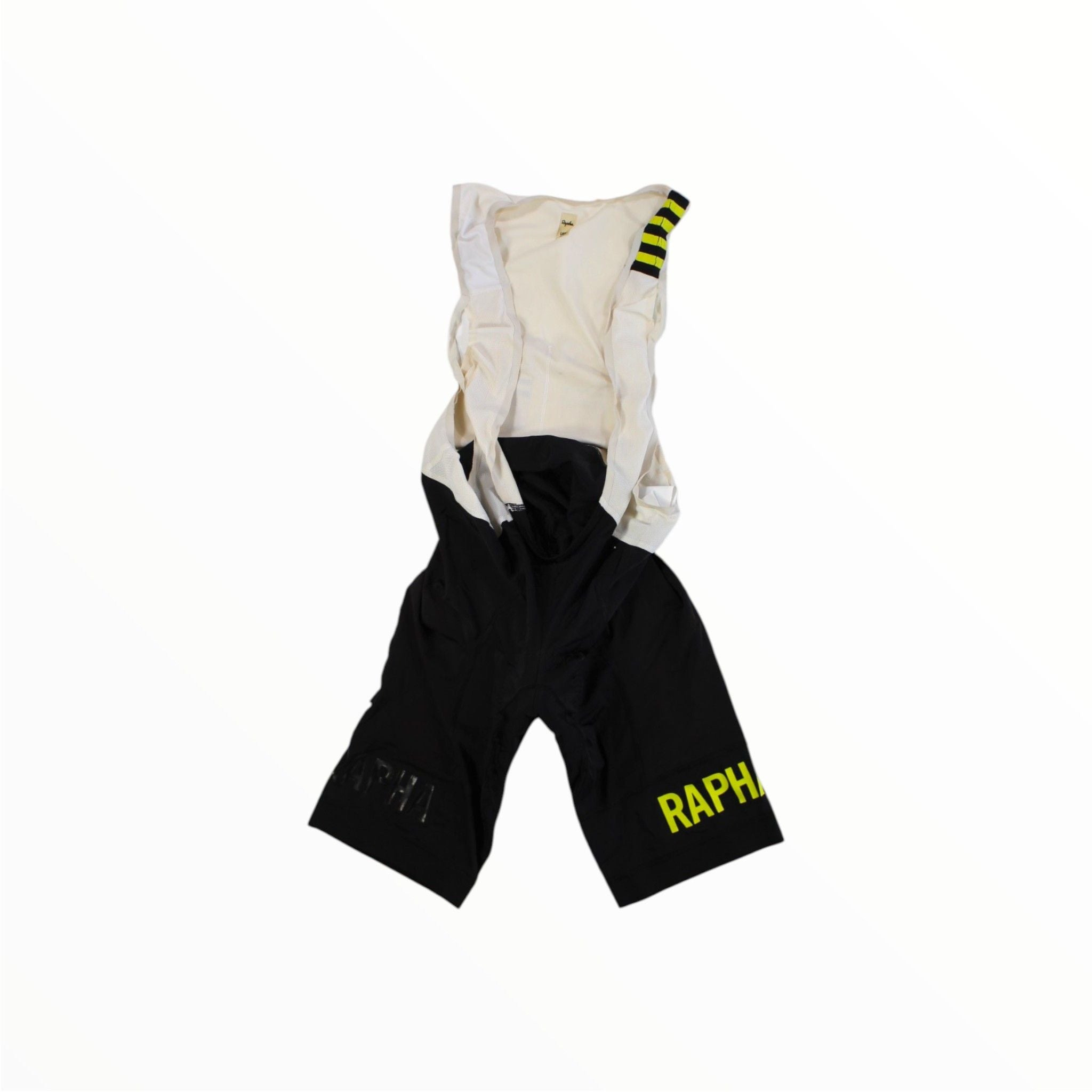Black and white Rapha Mens Pro Team Bib Shorts II - Long feature yellow RAPHA text on the left leg, a striped shoulder strap detail, and a dual-density chamois pad, shown on a white background.