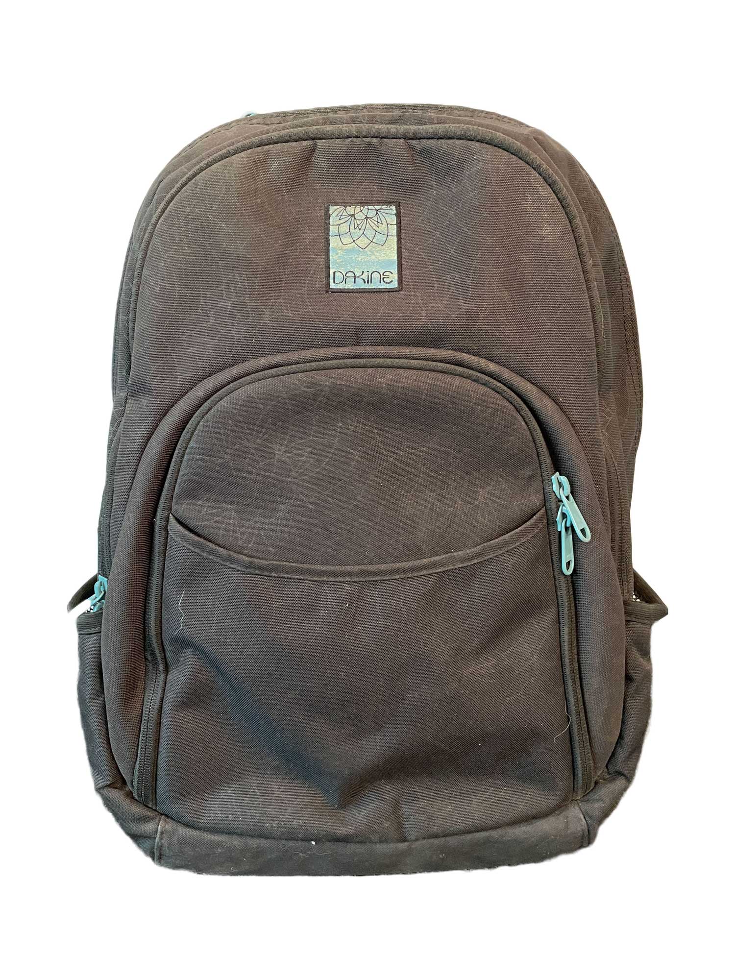 The Dakine Eve 28L Pack - Women's is a dark brown backpack with two zip compartments, a laptop sleeve, light blue zipper pulls, a subtle floral pattern, and a front Dakine logo patch. Shown on a white background.