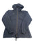 The Womens Arch Cape II Jacket in black features a hood, front zipper, two snap chest pockets, elastic cuffs, and a drawstring hem, displayed flat on a white background.