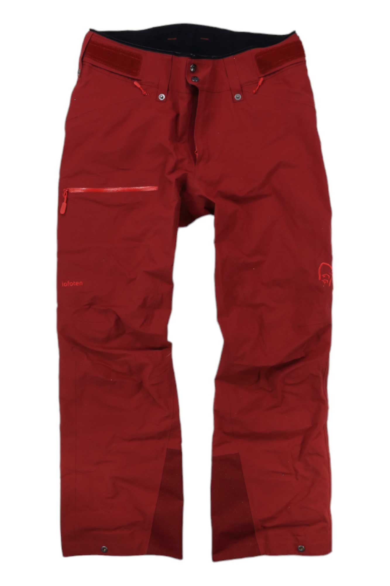 Norrona Womens Lofoten GORE-TEX Pants in red, with a zippered left thigh pocket, button waist closure, and reinforced ankle cuffs—ideal women's freeride pants for outdoor adventures. Displayed on a white background.