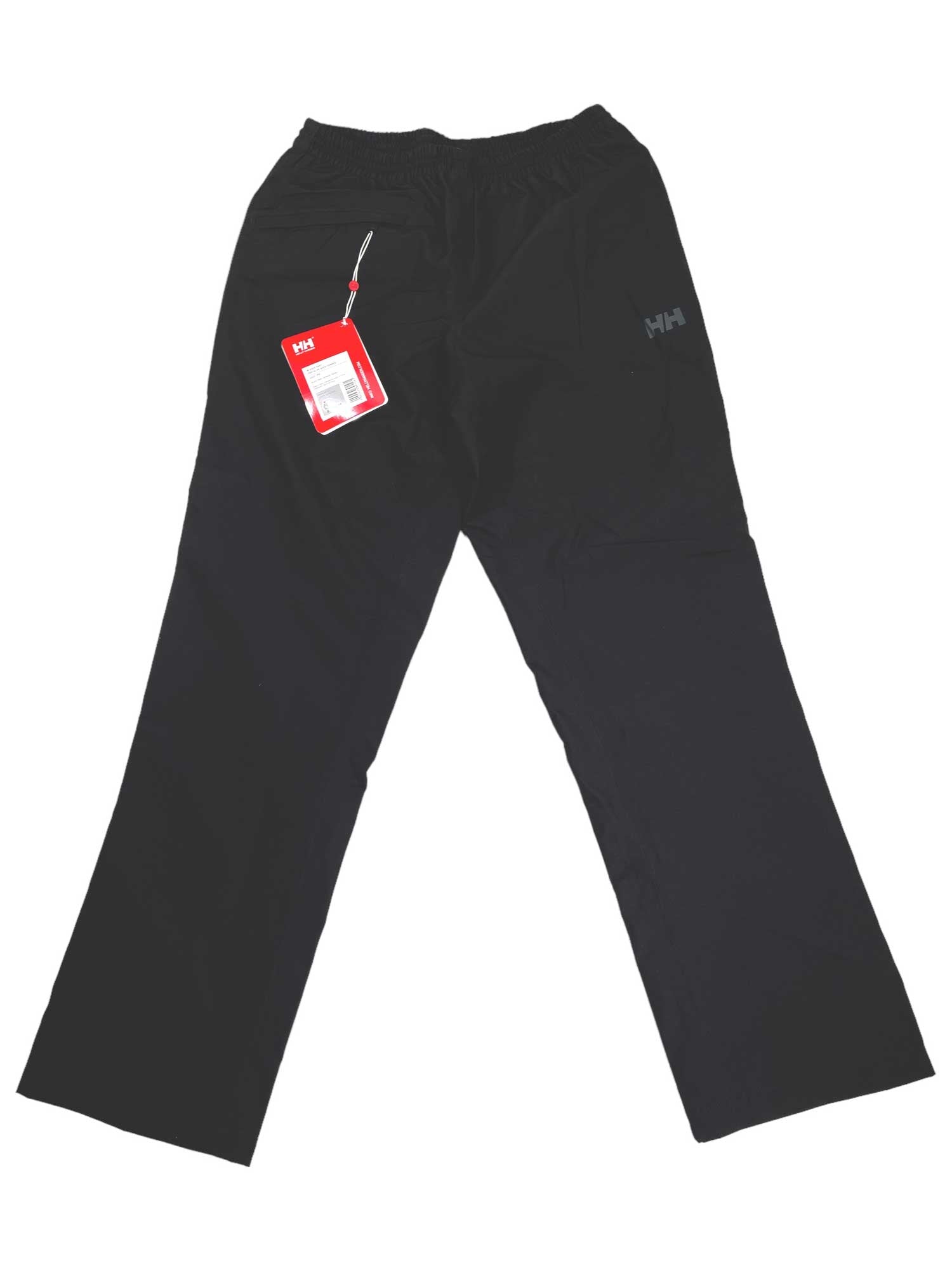 Black Helly Hansen Womens Aden Rain Pants with elastic waistband shown flat. A red tag hangs from a belt loop, and a small HH logo is on the upper left thigh.