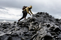 person climbing pile of rocks