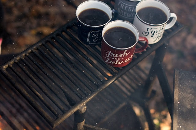 coffee cups sitting on a grill grate