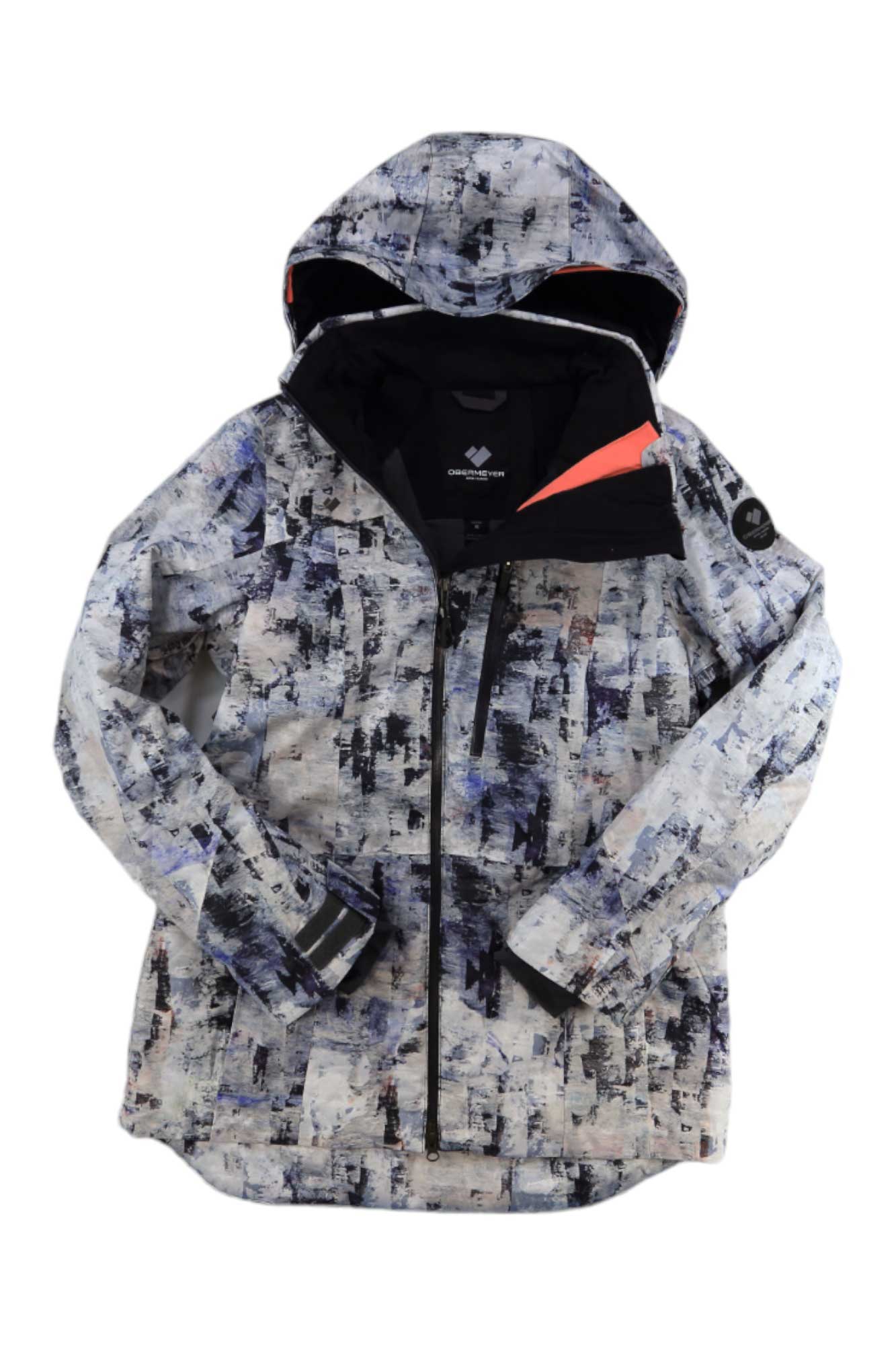 The Obermeyer Womens First Chair Jacket is a hooded ski coat with PrimaLoft insulation, a black zipper, and an abstract print in white, black, gray, and blue. It also features a high collar and a patch logo on one arm.