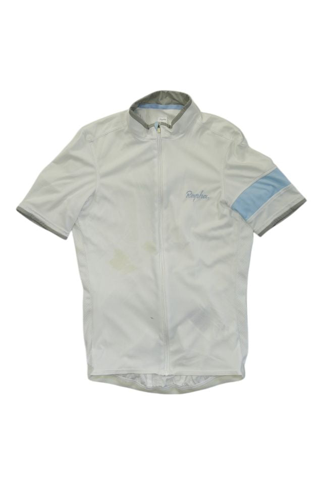 The Rapha Men's Super Lightweight Jersey is a white, short-sleeve cycling jersey with a light blue armband on the left sleeve, a front zipper, and grey trim on the collar and sleeve edges.