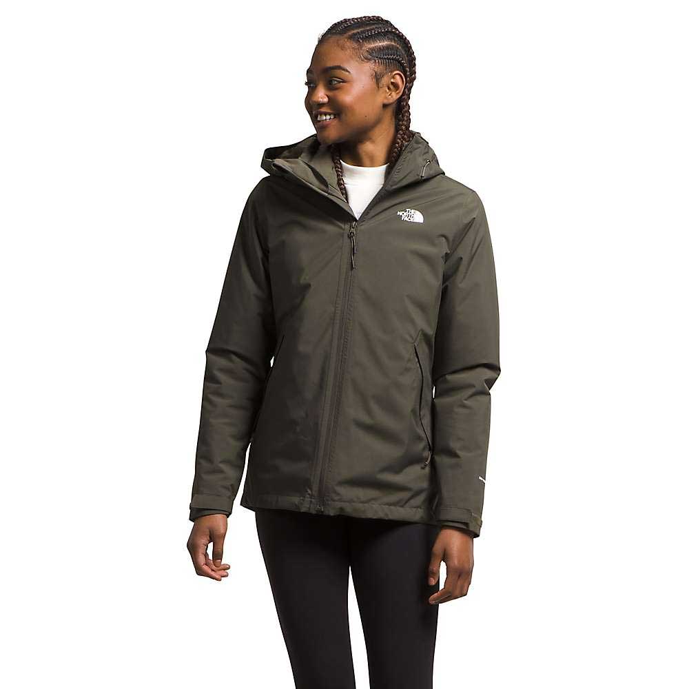 A woman with braided hair smiles and looks left, wearing an olive green The North Face Women's Carto Triclimate Jacket with a front zipper and chest logo, paired with black leggings.
