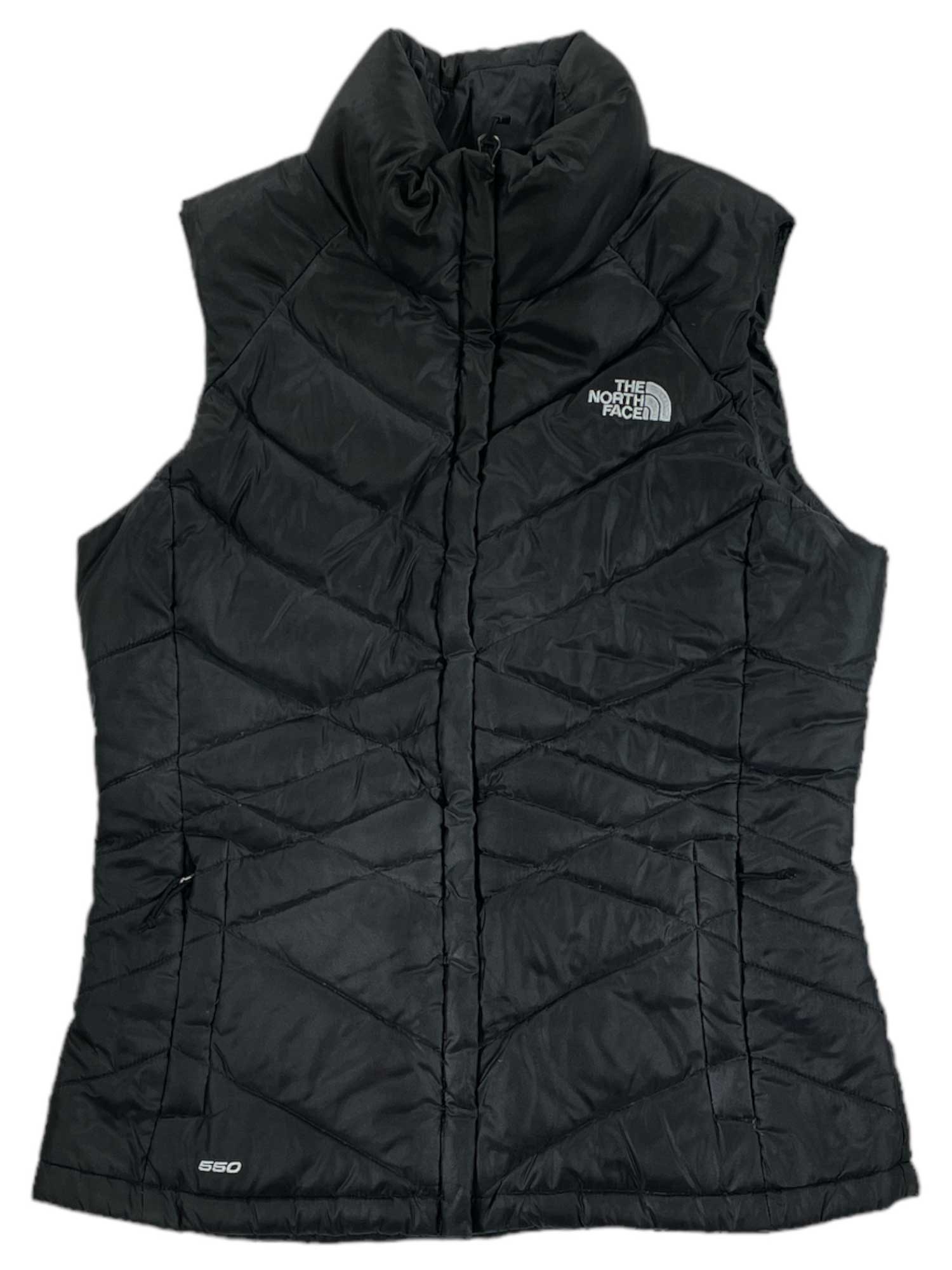 The North Face Womens Aconcagua Vest is a black, sleeveless vest with a high collar, featuring the logo on the chest and "600" near the hem. This wind-resistant, quilted vest uses recycled synthetic insulation for lightweight warmth.
