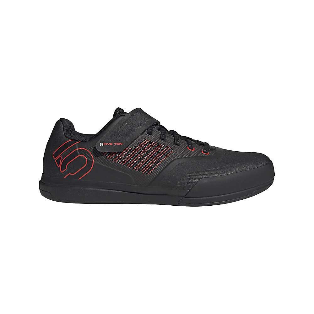 The Five Ten Men's Hellcat Pro Shoe is a black athletic shoe with red accents, red stitching, and a red heel outline. It features a durable synthetic upper, black laces, a strap over the tongue, and a flat black sole.