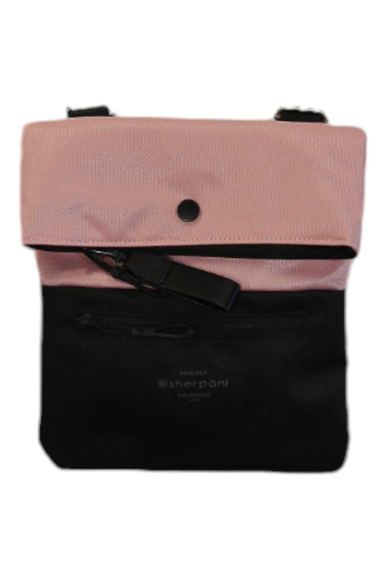 The Sherpani Womens Pica Cross Body Bag features a pink flap, black body, zippered front pocket, adjustable shoulder strap, and visible Sherpani branding. Made from recycled materials.