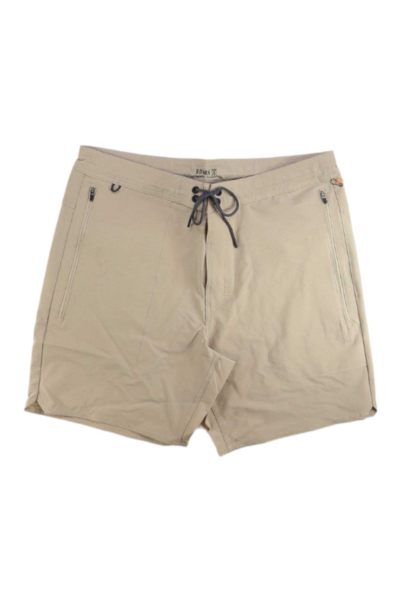 The Roark Mens Layover Trail Short 3.0 in light beige features a drawstring waistband and two front vertical zippered pockets, shown laid flat on a white background.