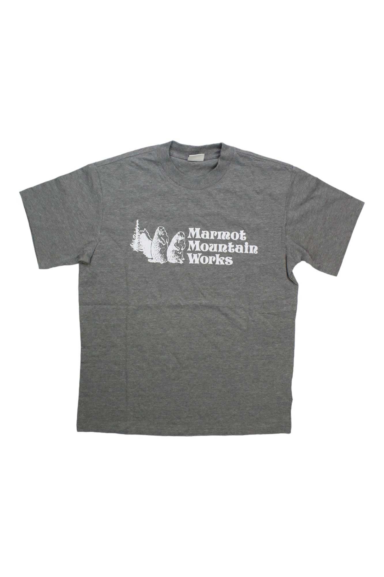 The Marmot Mens MMW Heavyweight SS Tee is a gray short sleeve shirt with a white Marmot Mountain Works logo plus mountain and marmot graphics on the front, designed for lasting comfort.
