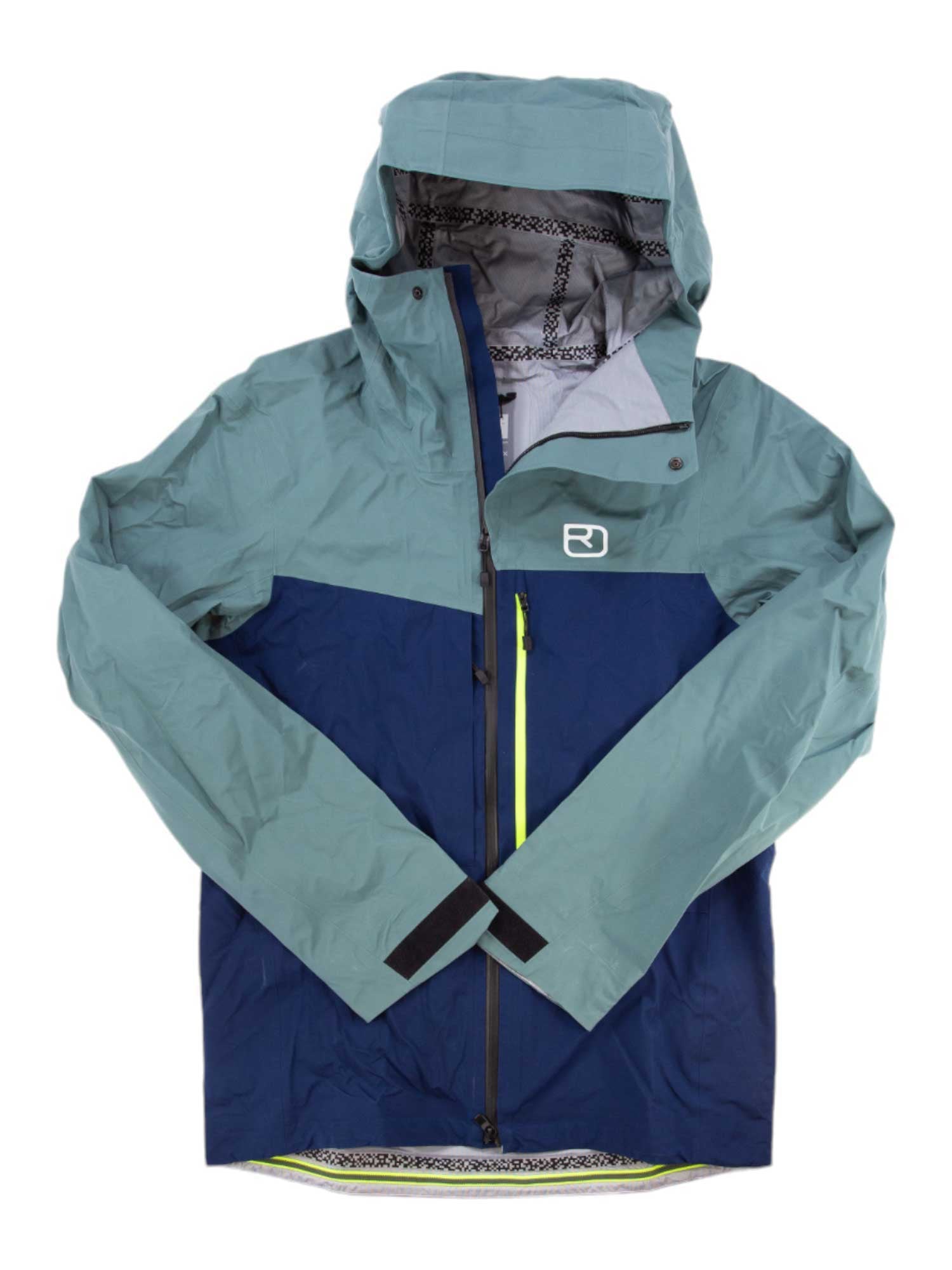 The Ortovox Mens Ravine 3L Shell Jacket is a men's two-tone shell with a hood for freeride skiing, featuring light teal on the upper part and sleeves, navy blue on the lower, a front zip, and a white chest logo.