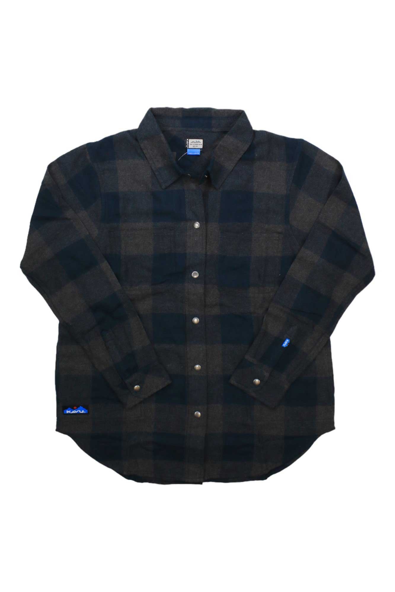 The KAVU Women’s Wren Shirt is a long sleeve button-up shirt jacket in black and dark gray plaid organic cotton flannel with a spread collar and front buttons, shown laid flat on a white background.