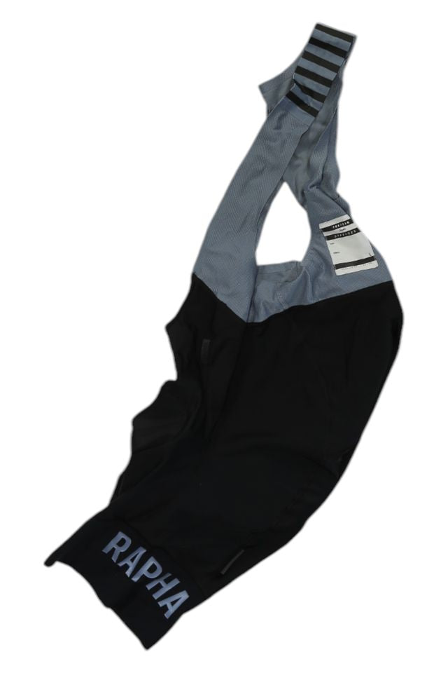 A pair of black and gray Rapha Mens Pro Team Bib Shorts II - Regular with RAPHA branding on the leg, striped shoulder straps, and a race-grade chamois for superior comfort during intense rides.