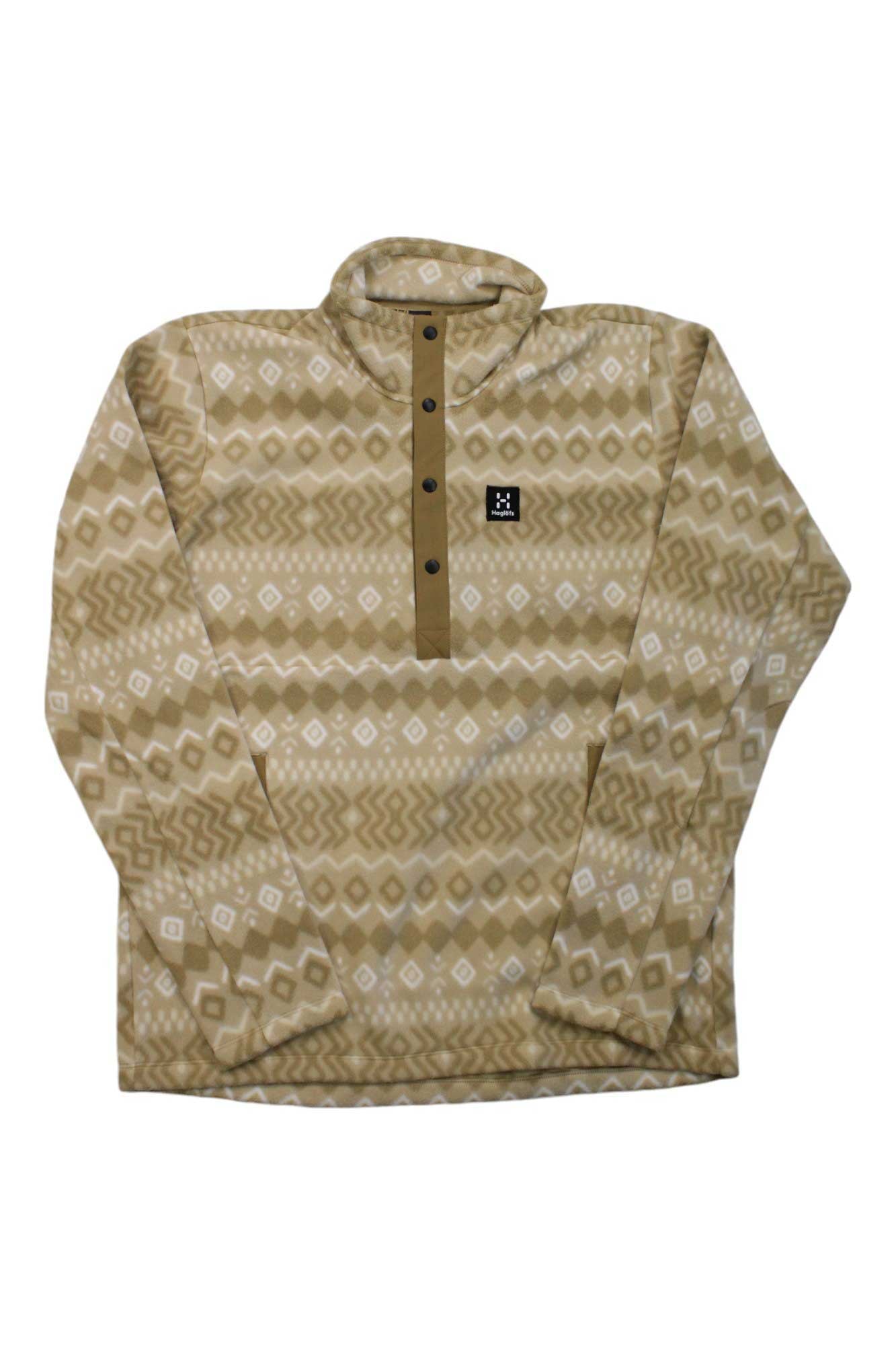 The Haglofs Men's Mora Midlayer Top is a beige and tan long-sleeve fleece pullover featuring a geometric pattern, button-up neck, and square chest logo—perfect as an insulating hiking midlayer in cool weather.