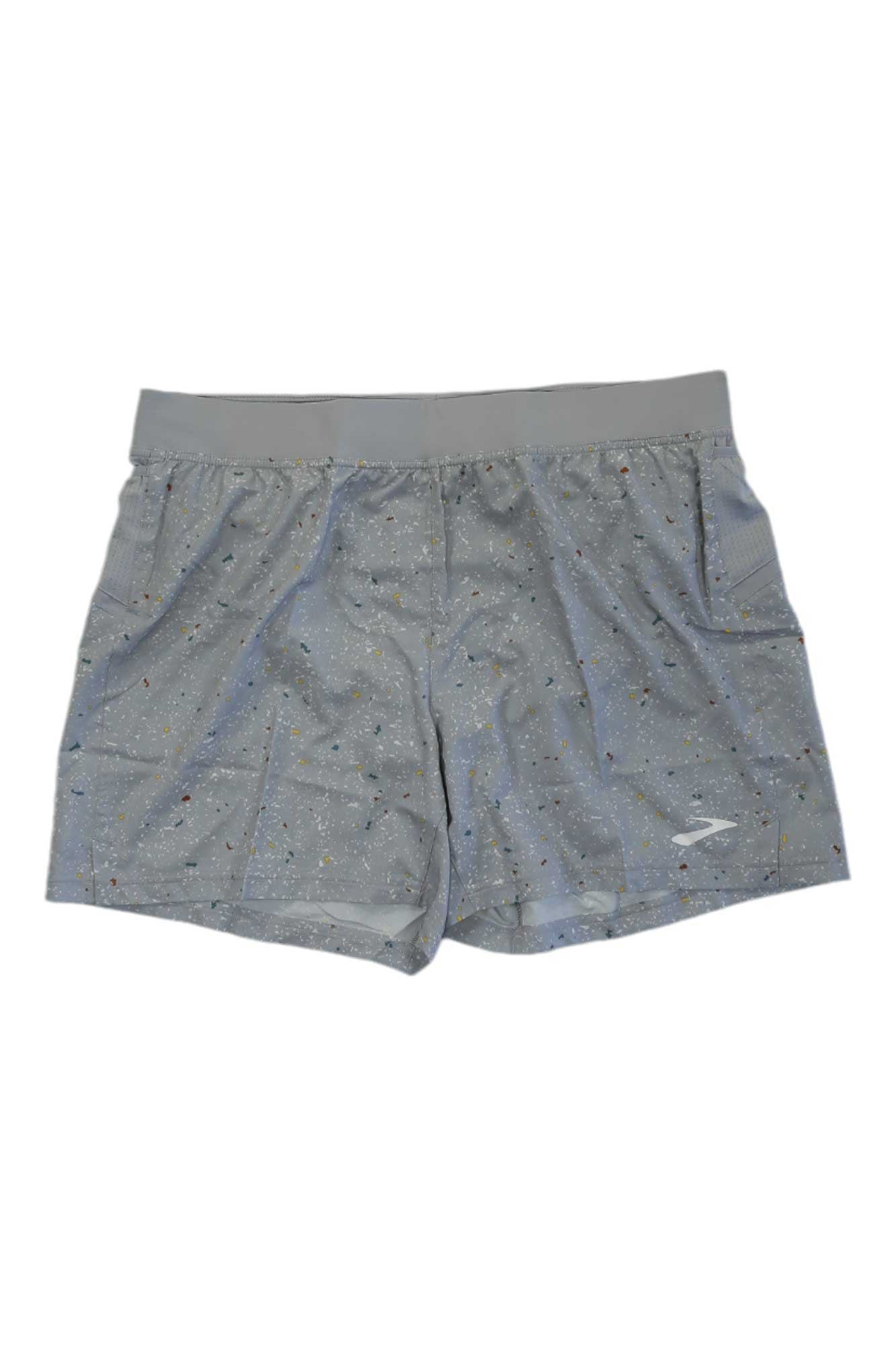 Brooks Men's Sherpa 5 Inch Short in gray features a subtle multicolor speckled pattern, moisture-wicking fabric, an elastic waistband, and side pockets. Displayed on a white background.