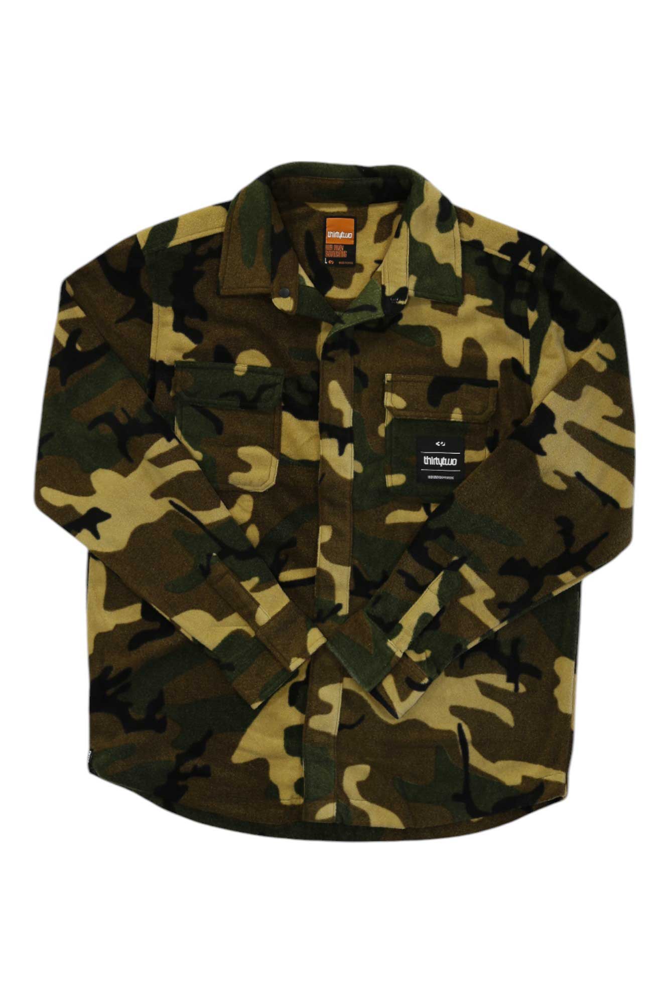 The ThirtyTwo Mens Rest Stop Shirt is a long-sleeve button-up with a green, brown, and black camo pattern and two chest pockets (one with a black label), combining comfort and classic style for any adventure.