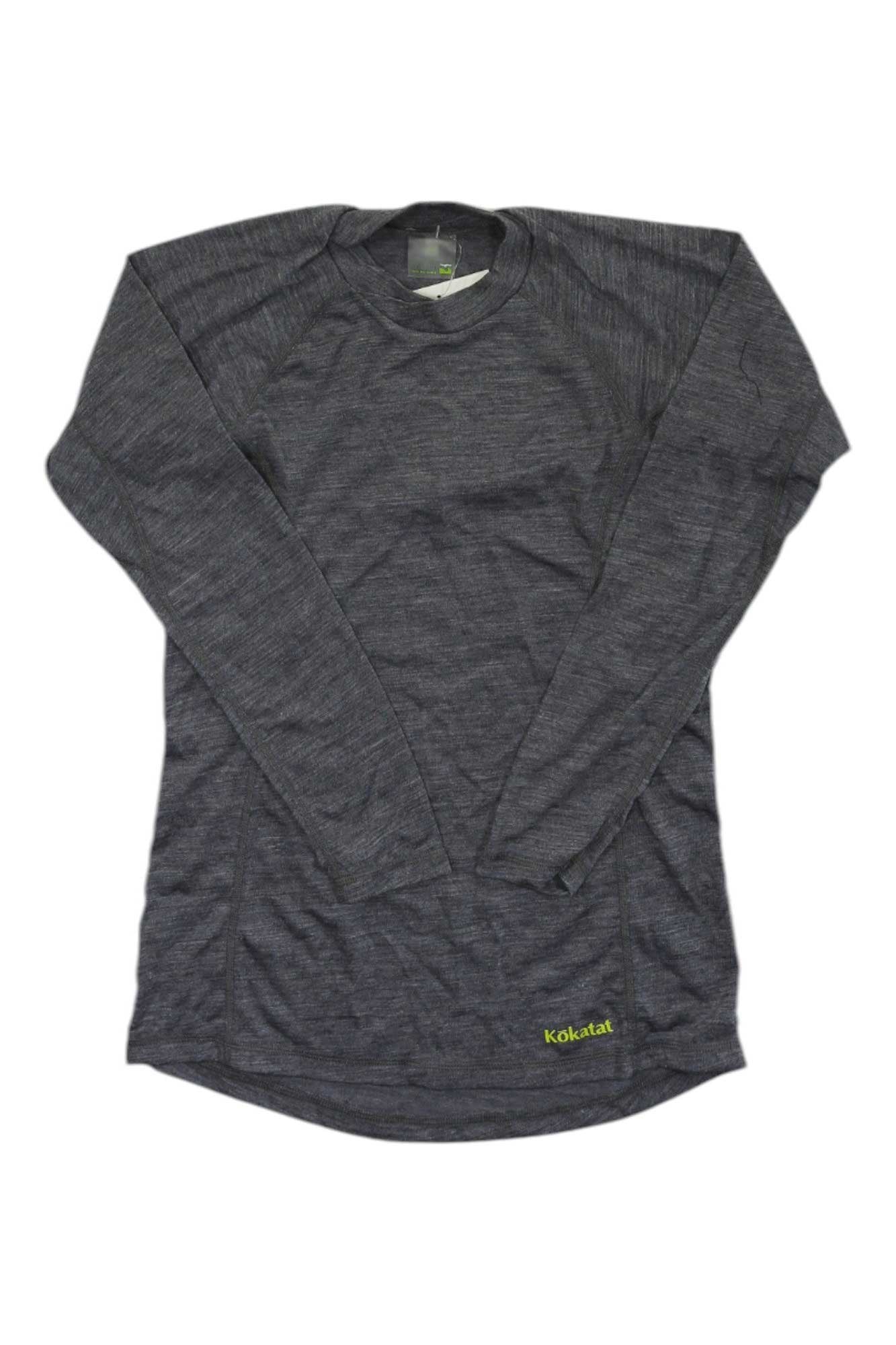 The Kokatat Womens WoolCore Long Sleeve Shirt is a dark gray, crew neck base layer with moisture-wicking fabric and subtle green branding near the hem, displayed flat on a white background.