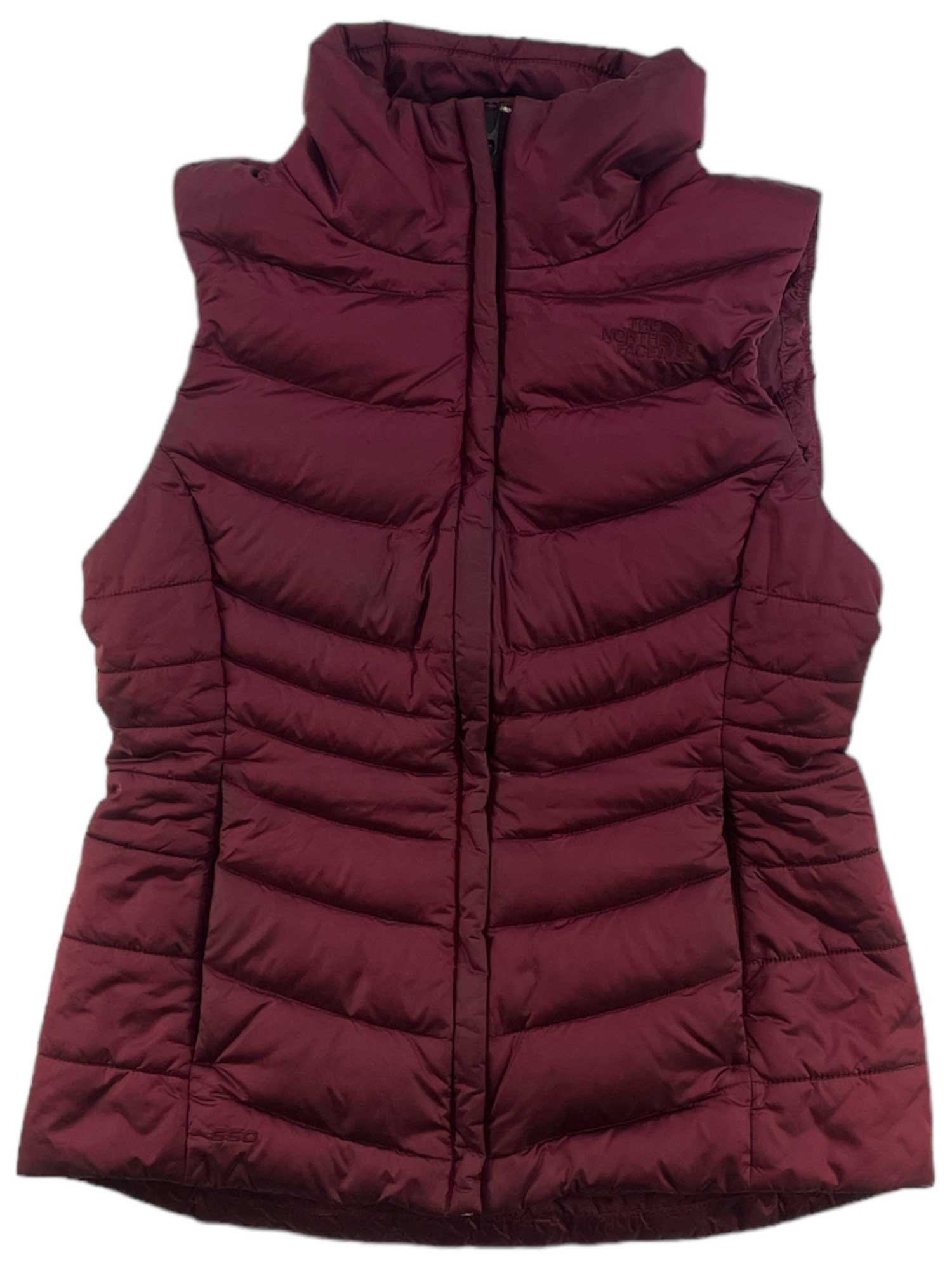 The North Face Womens Aconcagua Vest in maroon features a high collar, horizontal quilting, front zipper, and wind-resistant recycled insulation. This sleeveless vest is ideal for layering in cold weather.