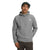 A person wearing The North Face Men's Alpine Polartec 100 Pullover in gray with the logo, along with a dark green cap, stands with one hand in their pocket against a white background.