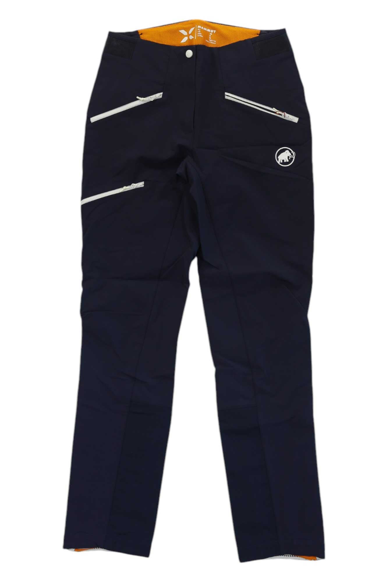 The Mammut Womens Eisfeld Advanced SO Pants are dark blue climbing pants for women, featuring three diagonal white-zippered pockets, an orange waistband lining, a white Mammut logo on the left thigh, and durable abrasion-proof soft shell fabric.