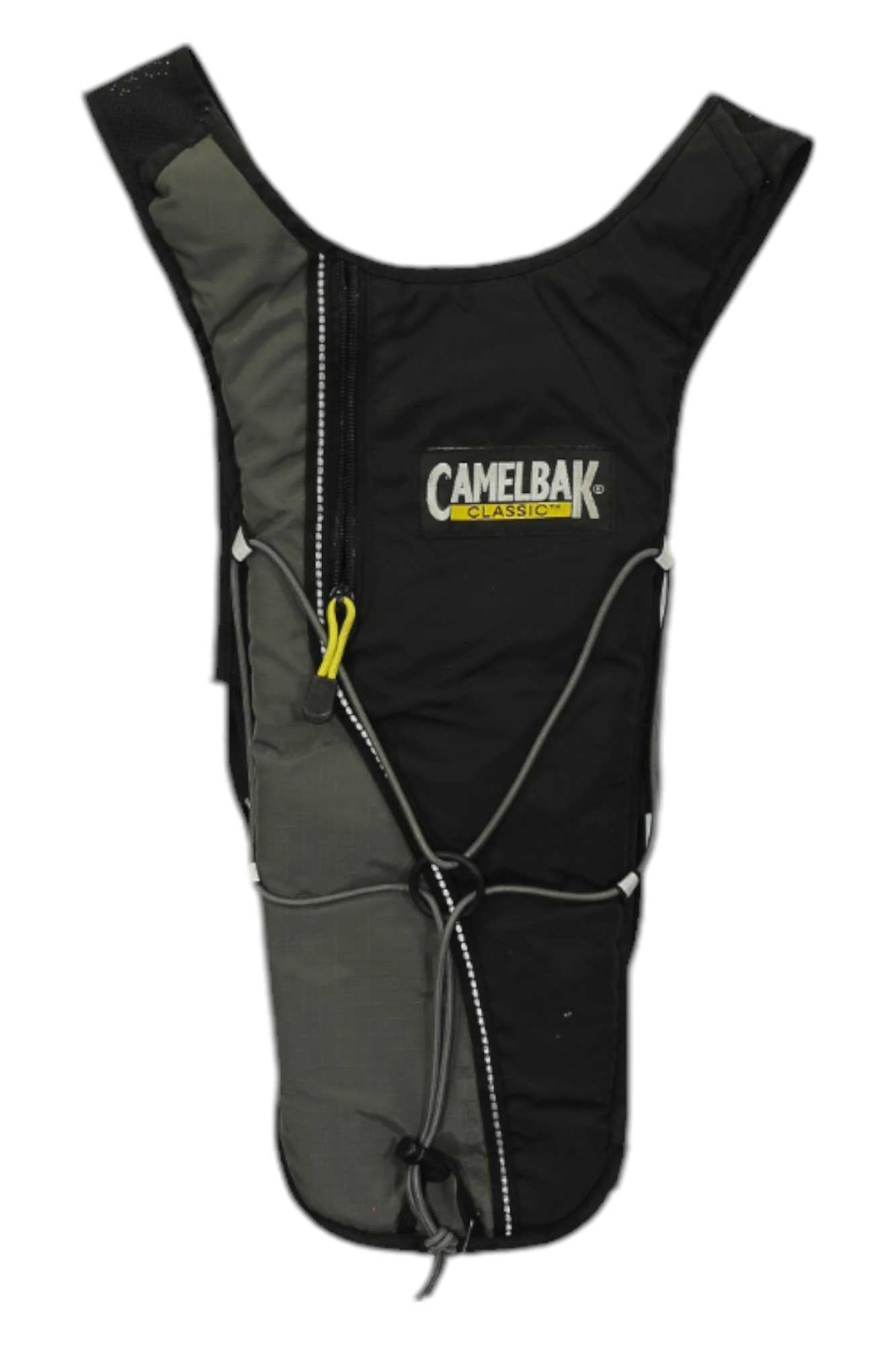 A black and gray Hydrobak Hydration Pack is upright, featuring a ventilated harness, zippered compartment with yellow pull, white reflective piping, and elastic cords across the front.