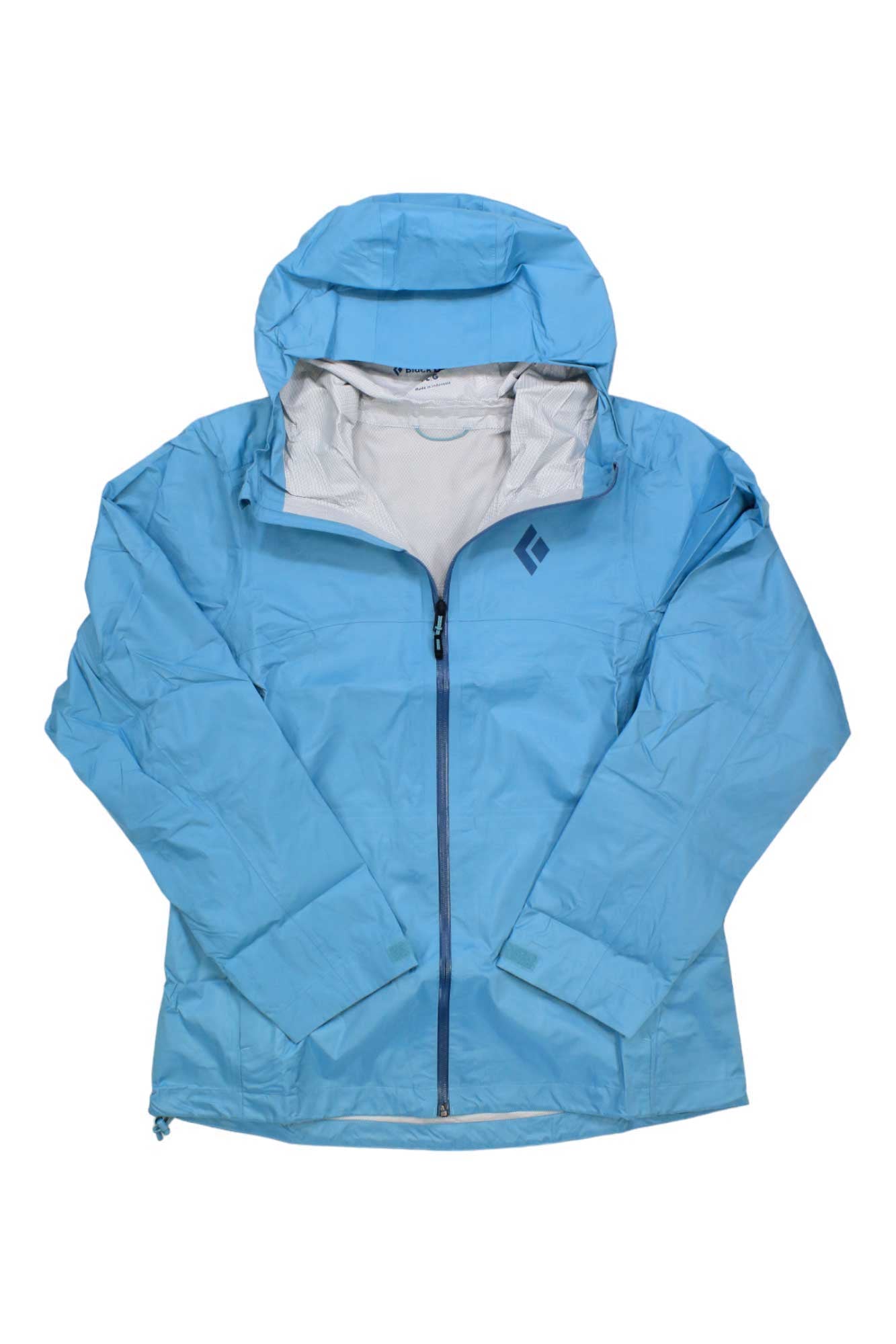 A Black Diamond Women's Treeline Rain Shell in light blue, featuring a front zipper, two side pockets, and a small left chest logo. This waterproof jacket is shown laid flat with crossed sleeves.