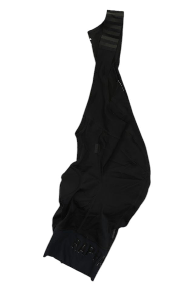 The Rapha Mens Pro Team Bib Shorts II - Regular in black, featuring subtle leg branding, a single shoulder strap, and a race-grade chamois, displayed against a white background.