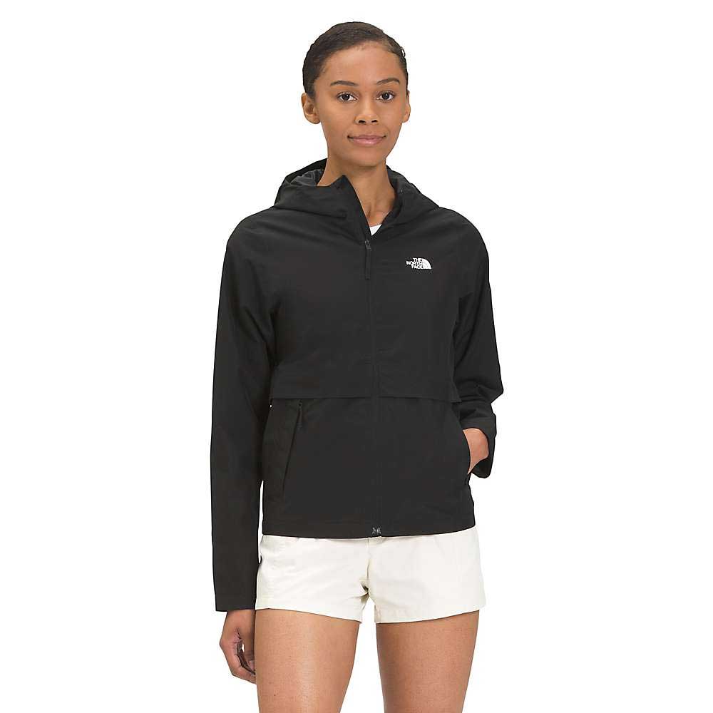 A woman stands facing forward, wearing The North Face Womens Hanging Lake Jacket—a black waterproof jacket with a DryVent 2L shell—and light-colored shorts against a plain white background.