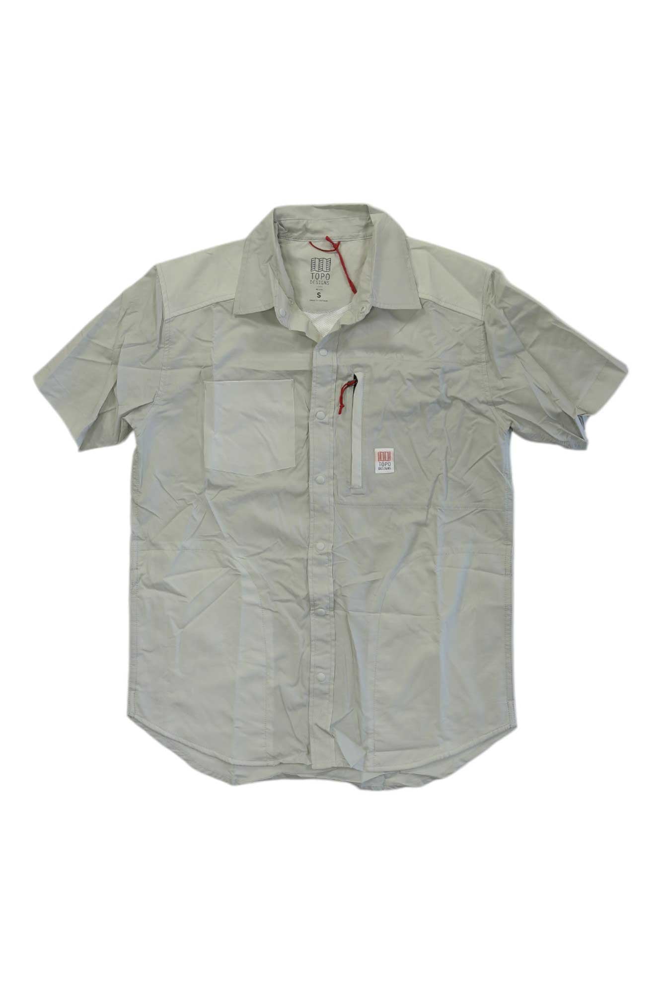 The Topo Designs Mens Short Sleeve Field Shirt is a light gray, short-sleeved shirt with a chest pocket and subtle red accent, shown slightly wrinkled and laid flat on a white background.