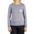 A person in the Moosejaw Womens Peak Original LS Pocket Tee—an organic cotton/recycled poly long sleeve shirt with a chest pocket, small mountain graphic, and "Moosejaw" text—paired with dark jeans against a white background.
