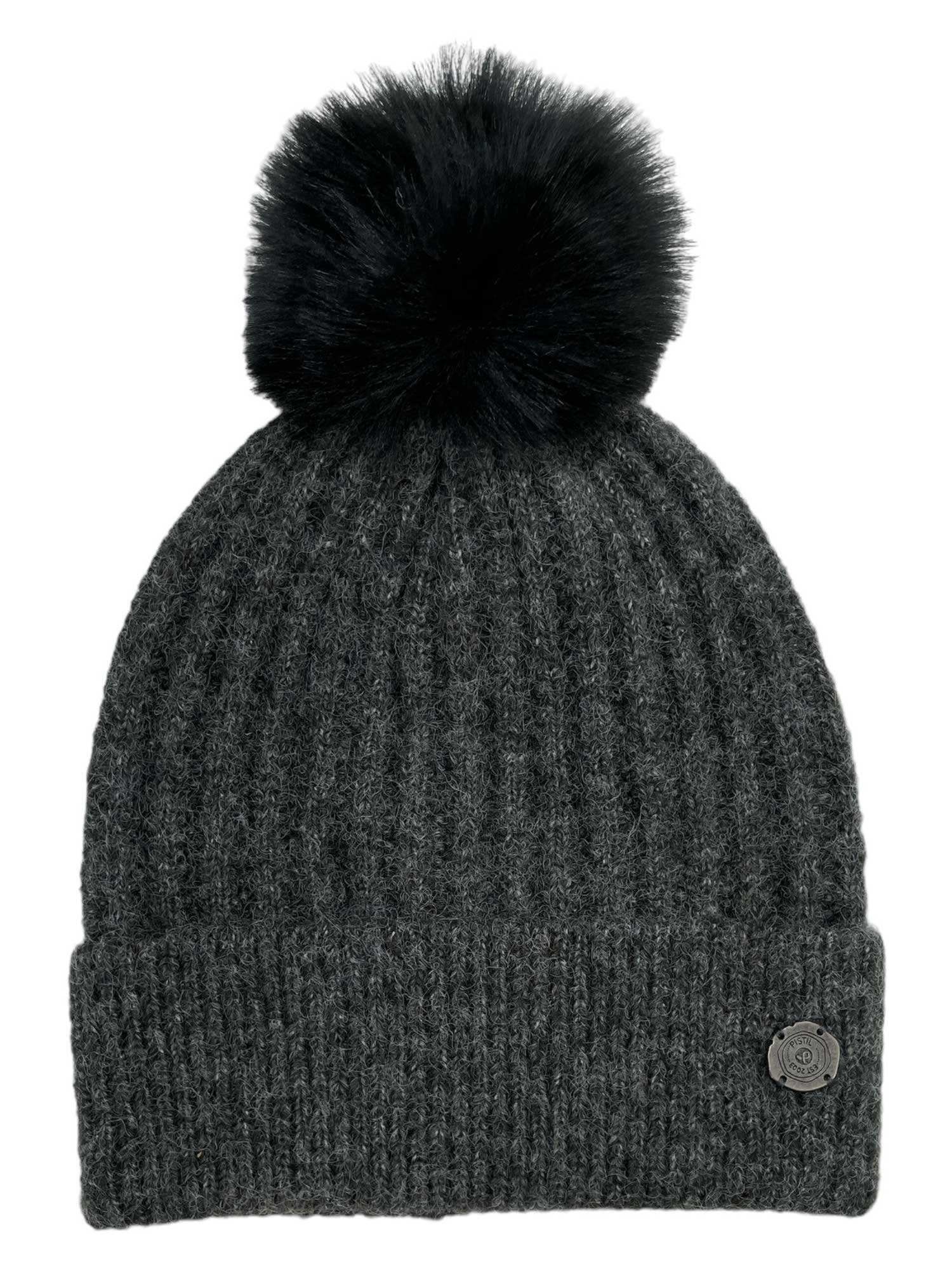 The Pistil Womens Piper Beanie is a dark gray, ribbed knit winter hat with a turned-up brim, small round metal logo, and a large black faux fur pom-pom—perfect for staying stylish and warm on cold days.