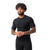 A man with curly hair and a beard smiles while wearing the Smartwool Men's Intraknit Active SS Top and matching pants, standing against a plain white background.