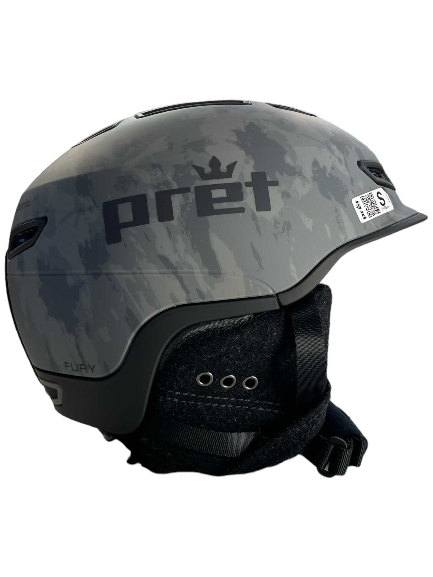 The Pret Men's Fury X Ski Helmet features a gray camouflage pattern, black trim, adjustable chin strap, ventilation holes, side barcode sticker, and an ultra lightweight design for maximum comfort.