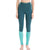 A person stands barefoot, wearing teal and light blue Icebreaker Womens 200 Zoneknit Legging made from soft Merino wool. The high-waisted, body-mapped design features the icebreaker brand on the waistband. Only the lower torso and legs are visible.