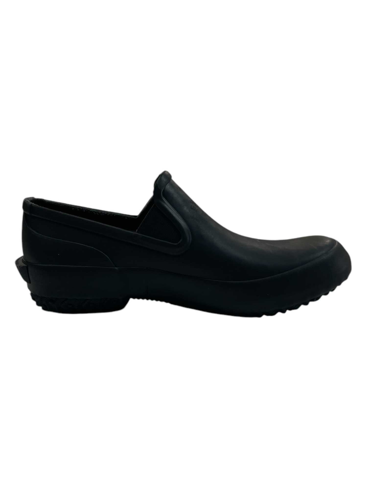 The Bogs Women's Patch Slip Solid Shoe, a black waterproof slip-on with a low heel and textured sole, ideal for winter camping, is displayed in side profile against a white background.