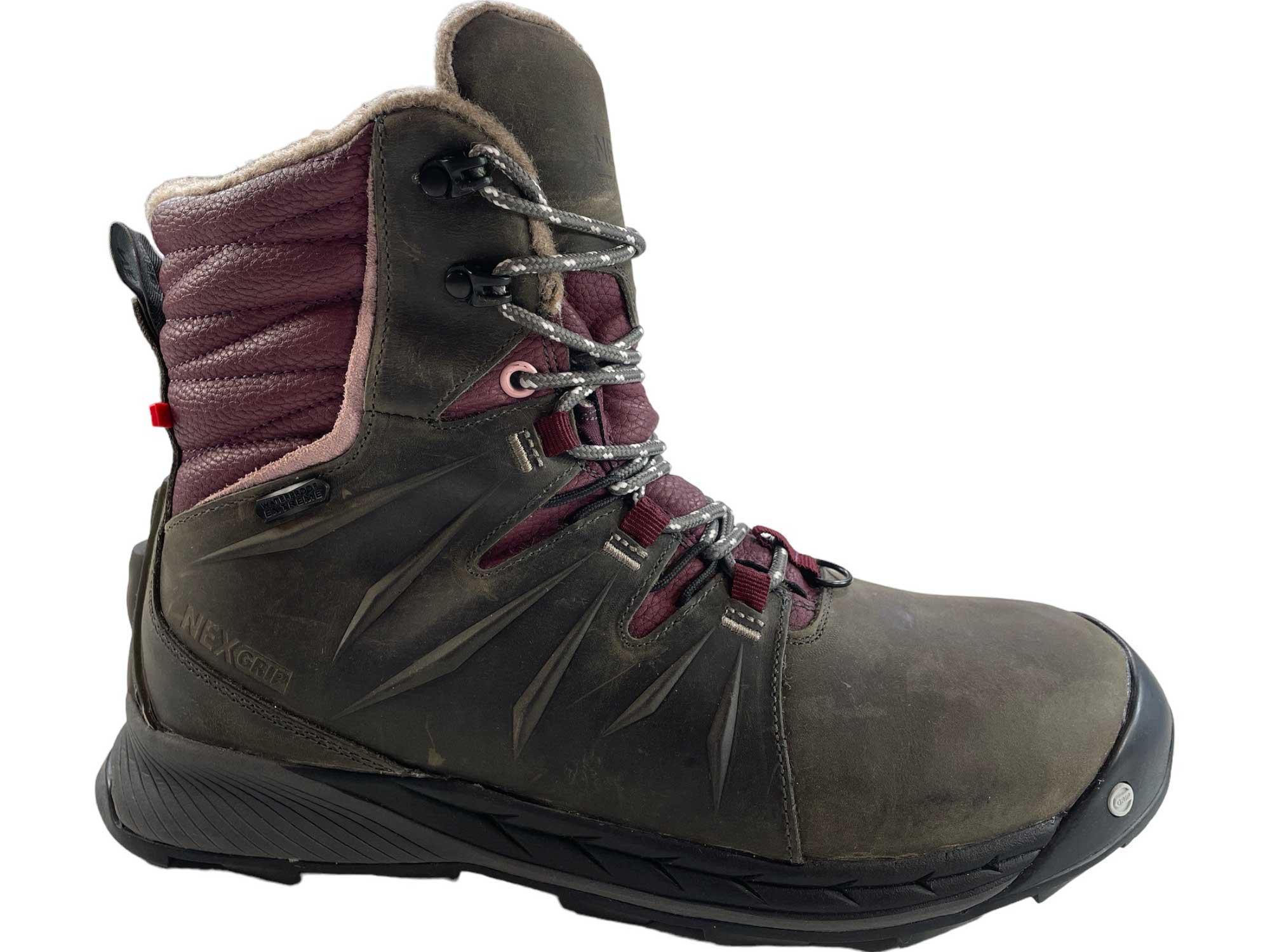 The NexGrip Women's Ice Meli Boot is a rugged, waterproof winter boot with brown leather, maroon fabric, metal eyelets, thick black laces, high ankle support, insulated lining for warmth, and a retractable crampon.