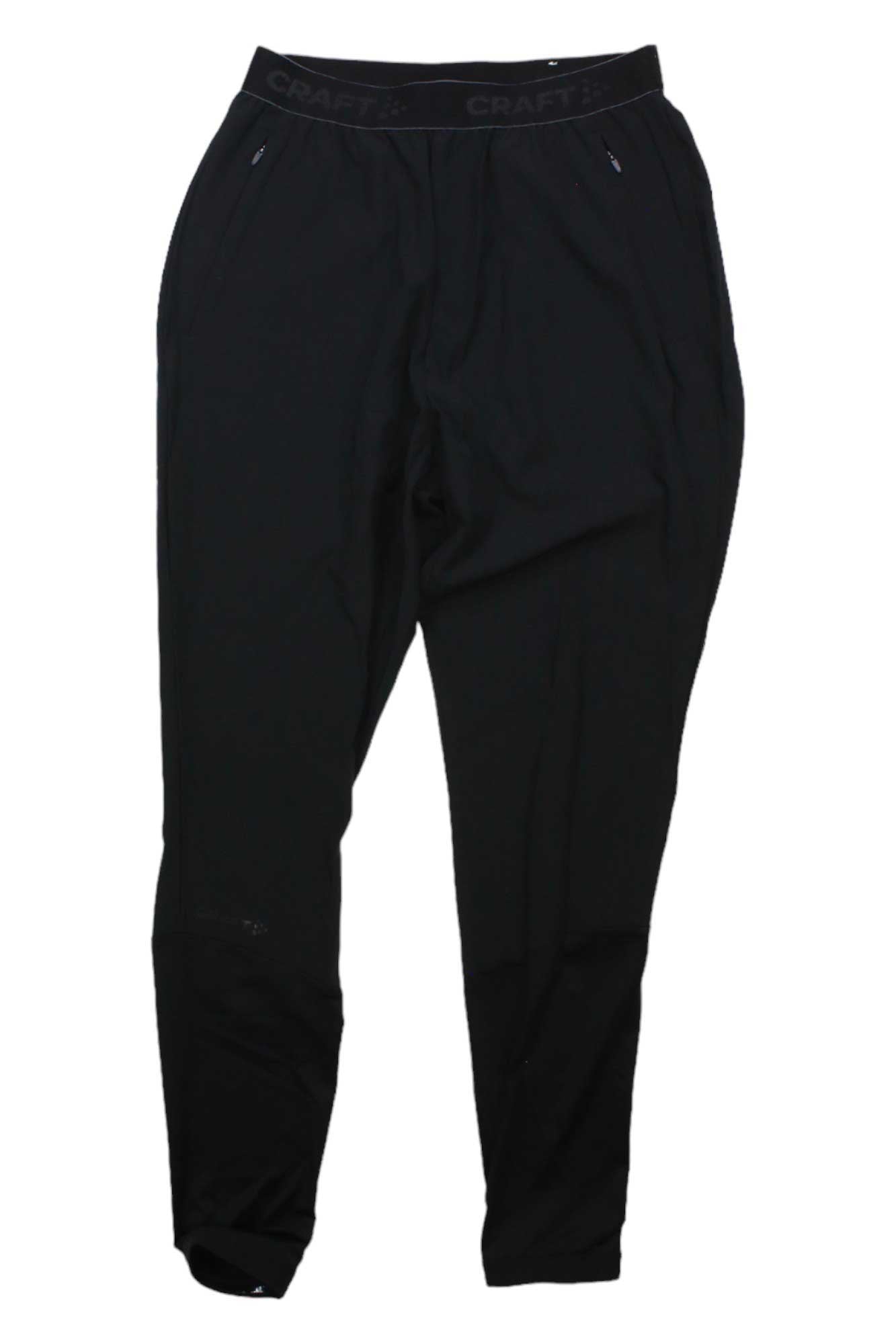 The Craft Sportswear Mens ADV Essence Training Pant is a pair of slim-fit black training pants for men, made from recycled polyester with zippered pockets and an elastic waistband, shown on a white background.