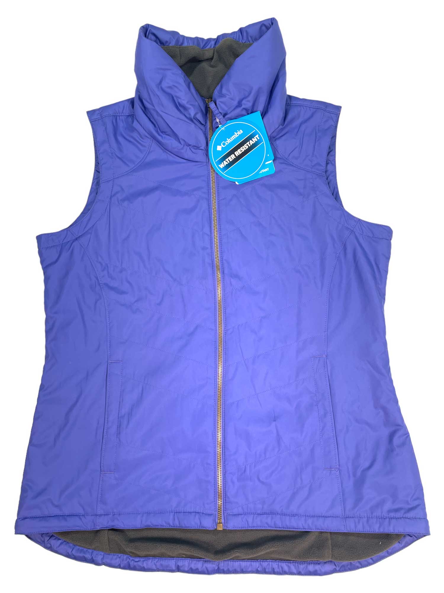 The Women's Marion Junction EXS Vest by Columbia is a sleeveless, purple, water-repellent vest with a high collar, front zipper, blue logo tag near the top, and soft fleece lining. It’s displayed flat on a white background.
