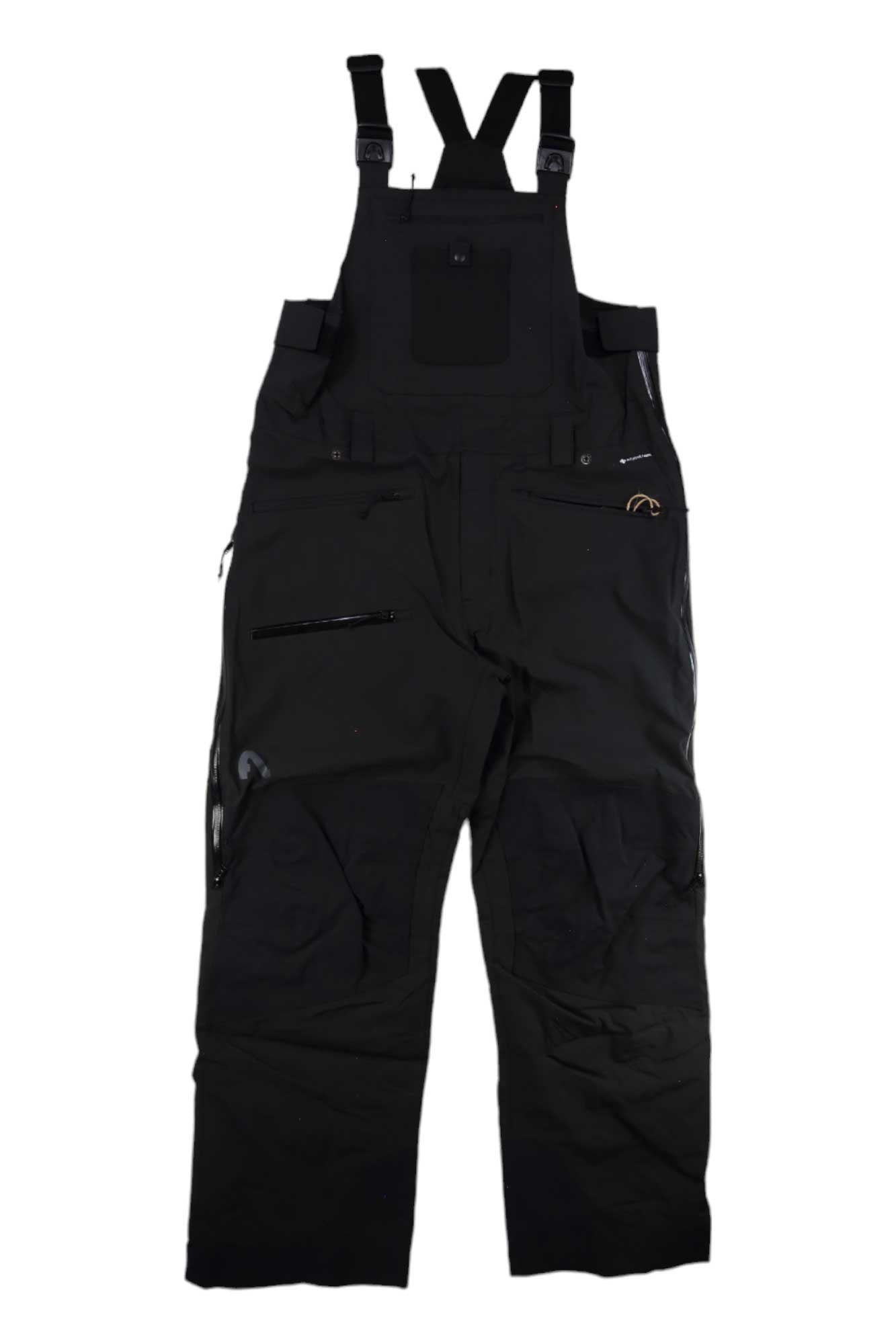 The Flylow Men's Baker Insulated Bib by Flylow, in black, features adjustable shoulder straps, multiple zippered chest and leg pockets, and reinforced knees; shown laid flat on a white background.