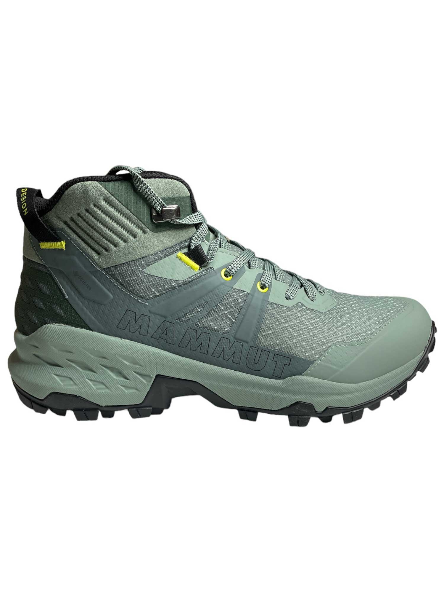 The Mammut Womens Sertig II Mid GTX Shoe is shown in green with yellow accents, a rugged sole, and high ankle support in side profile against a white background. This lightweight shoe is perfect for tackling demanding trails.