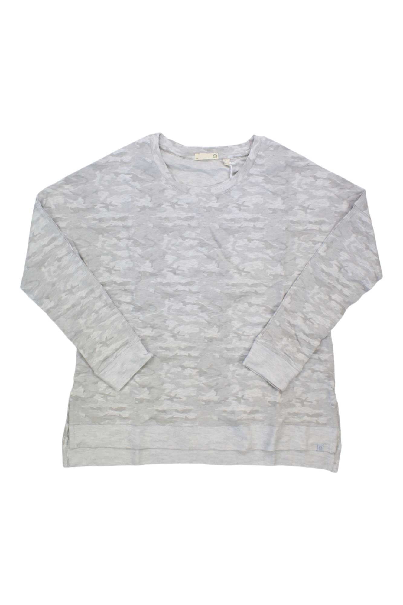 The Tasc Women's Riverwalk Lightweight French Terry Sweatshirt in light gray features a subtle camouflage pattern, crew neckline, and ribbed cuffs. Made from organic cotton, it's perfect for travel or everyday wear. Shown laid flat on a white background.